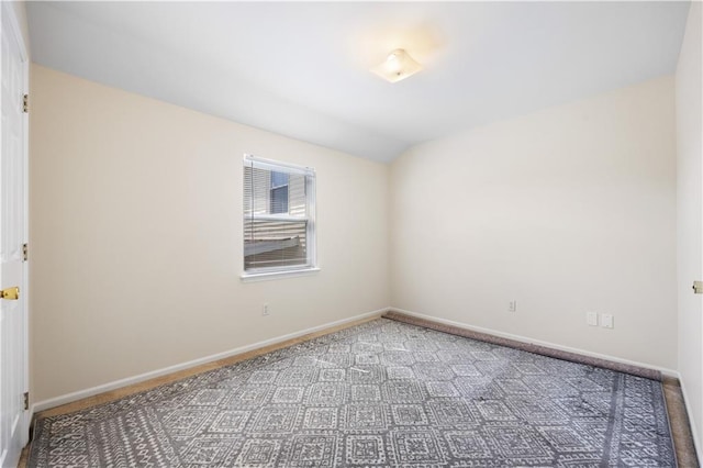 spare room with carpet flooring and lofted ceiling