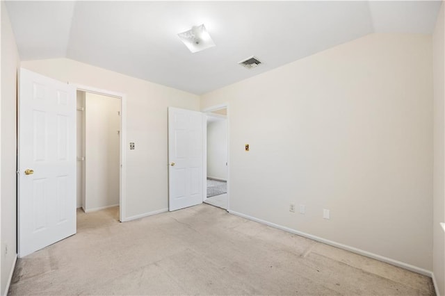 unfurnished bedroom with light carpet and lofted ceiling