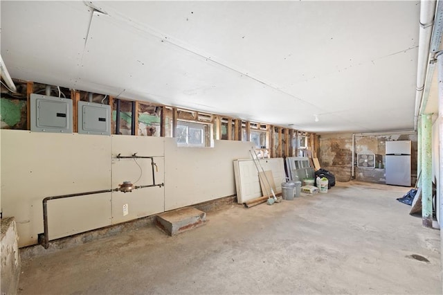 basement featuring electric panel and fridge