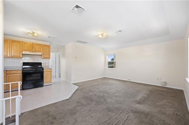 kitchen with black gas range oven, light brown cabinets, light colored carpet, and tasteful backsplash