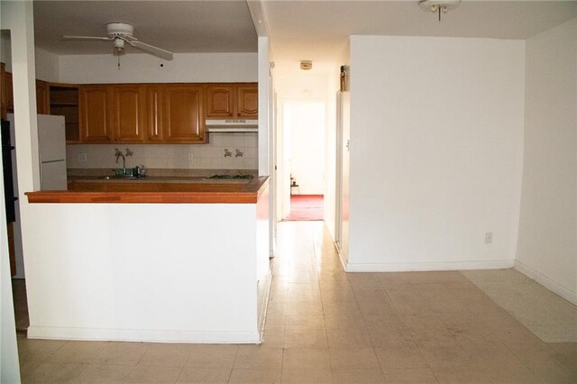 kitchen featuring ceiling fan, sink, stainless steel gas stovetop, decorative backsplash, and light tile patterned floors