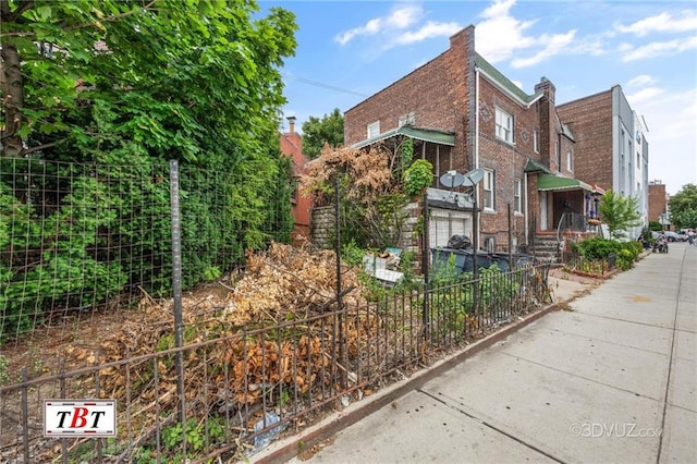 view of side of property with fence and brick siding