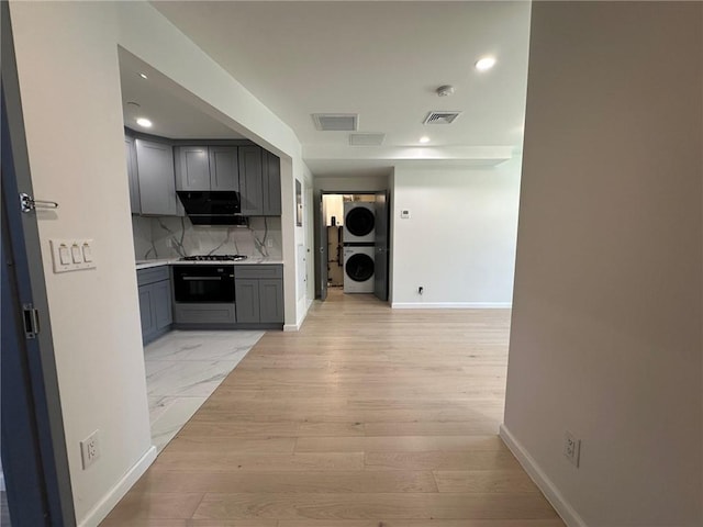 207 Bay 35th St Unit 1A, Brooklyn, NY 11214 - corridor featuring stacked washing machine and dryer, recessed lighting, and light wood-style floors