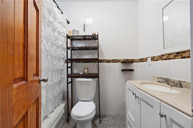 bathroom featuring tile walls, vanity, and toilet