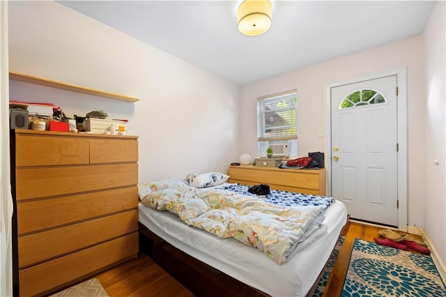 bedroom with cooling unit and wood finished floors