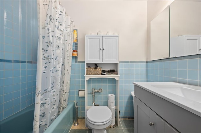 bathroom with vanity, tile walls, shower / bath combo, and toilet