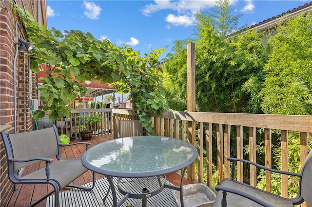 view of wooden balcony featuring a wooden deck and outdoor dining area