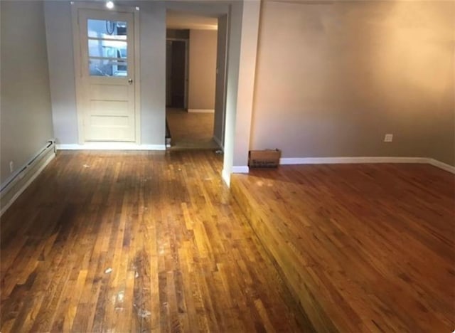 spare room with baseboards and hardwood / wood-style floors