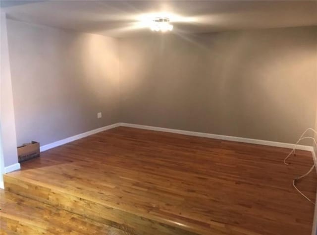unfurnished room featuring baseboards and wood finished floors
