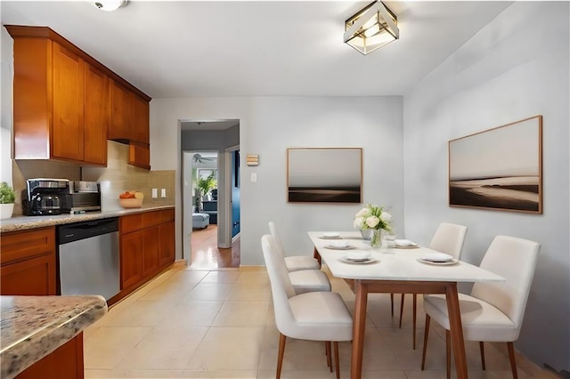 kitchen with brown cabinetry, decorative backsplash, and dishwasher