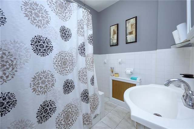 full bath with tile walls, radiator, curtained shower, and a sink