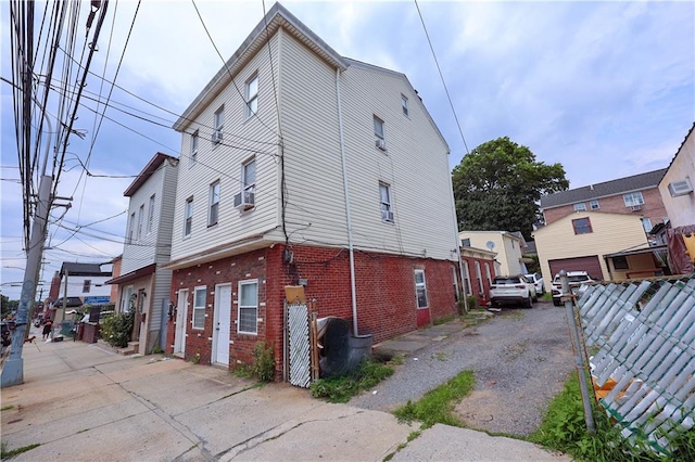 view of side of property featuring brick siding and cooling unit