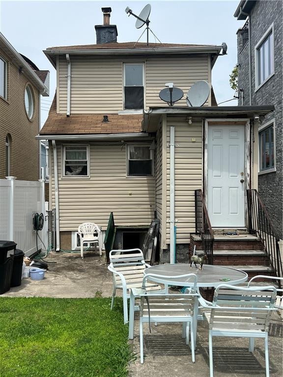 rear view of property featuring a yard and a patio area