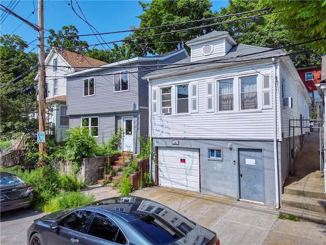 view of front of home with cooling unit and a garage