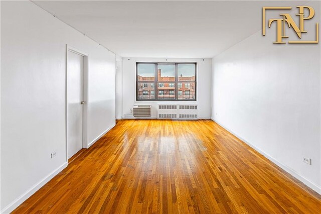 empty room featuring radiator and light hardwood / wood-style floors