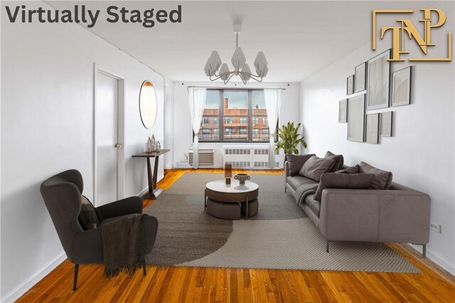 living room with radiator, hardwood / wood-style floors, and a notable chandelier