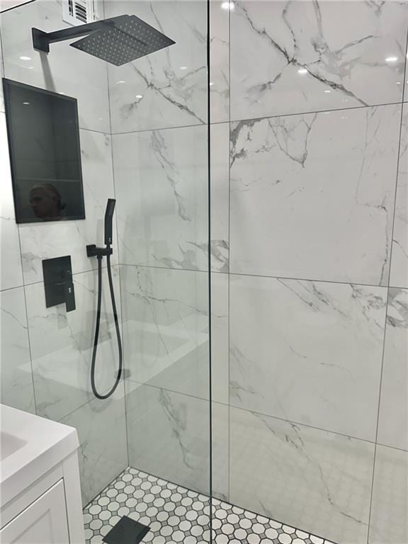 bathroom featuring a tile shower and vanity