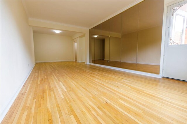 unfurnished room featuring crown molding and light hardwood / wood-style flooring