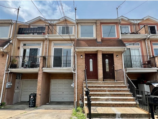 townhome / multi-family property featuring a balcony and a garage