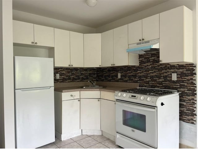 kitchen featuring light tile patterned flooring, sink, white appliances, tasteful backsplash, and white cabinetry