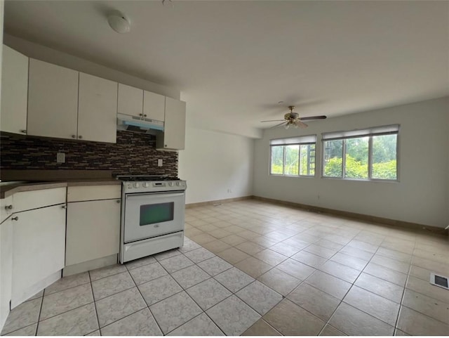 kitchen featuring ceiling fan, white electric range oven, light tile patterned floors, and tasteful backsplash