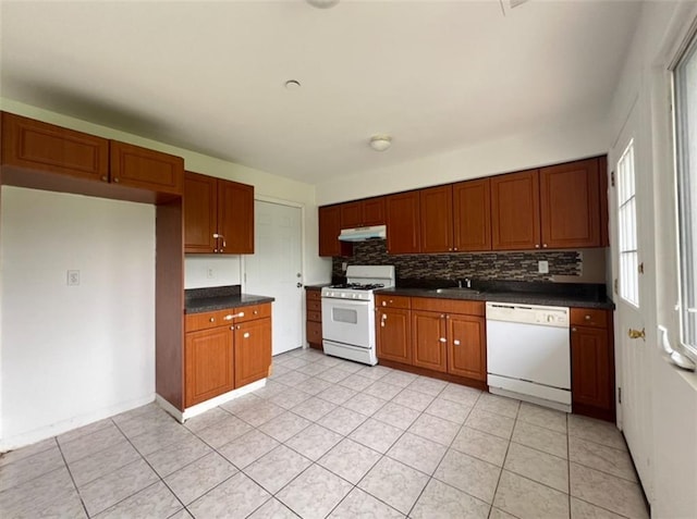 kitchen with decorative backsplash, white appliances, sink, and light tile patterned floors