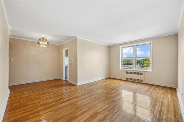 unfurnished room featuring crown molding, radiator, and hardwood / wood-style flooring