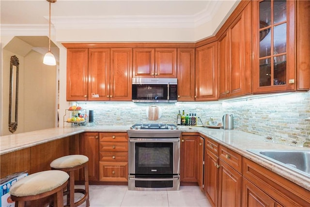 kitchen featuring ornamental molding, stainless steel appliances, light stone counters, and decorative light fixtures