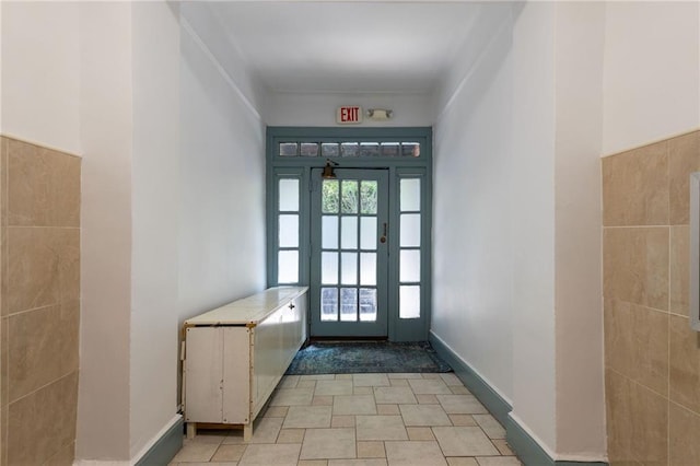 doorway to outside with tile walls