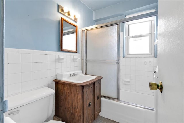 full bathroom with vanity, enclosed tub / shower combo, tile walls, and toilet