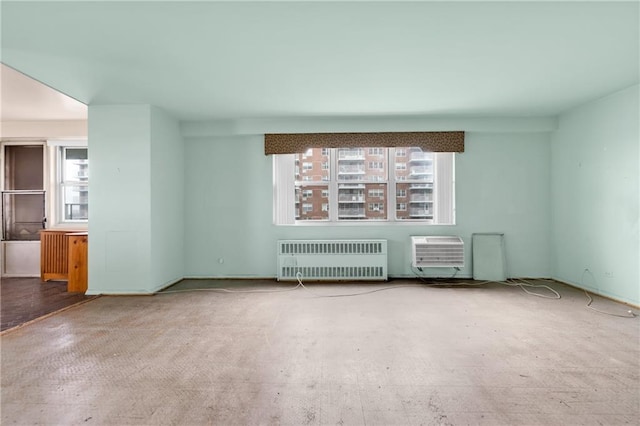 unfurnished living room with a wall mounted AC, radiator, and a wealth of natural light