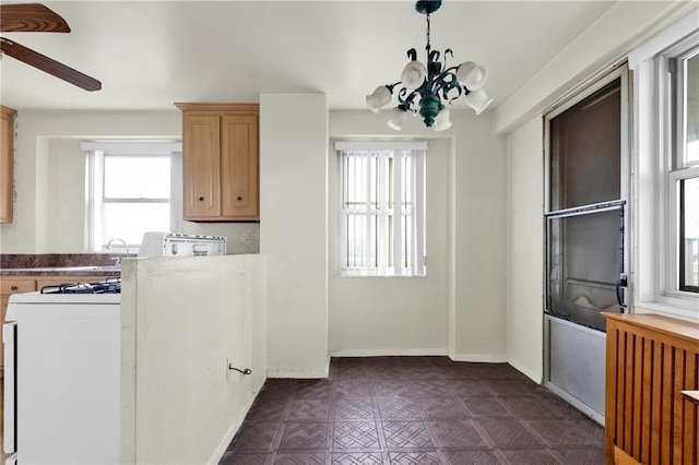 kitchen featuring white gas range and ceiling fan with notable chandelier