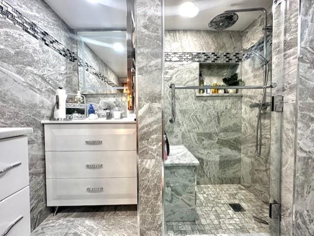 bathroom featuring vanity, a shower with door, and tile walls