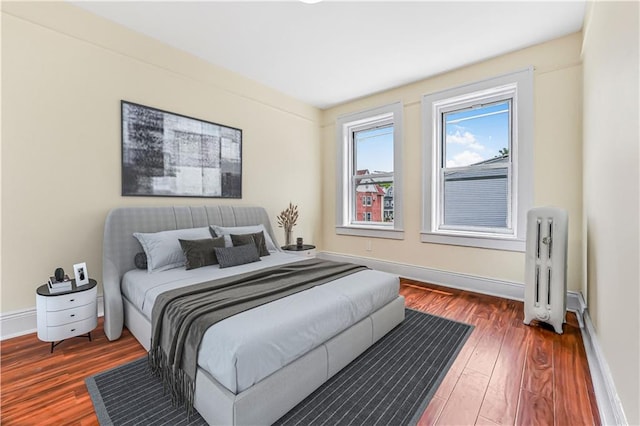 bedroom with radiator and dark hardwood / wood-style floors