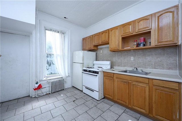 kitchen featuring sink, light tile patterned floors, radiator heating unit, white appliances, and decorative backsplash