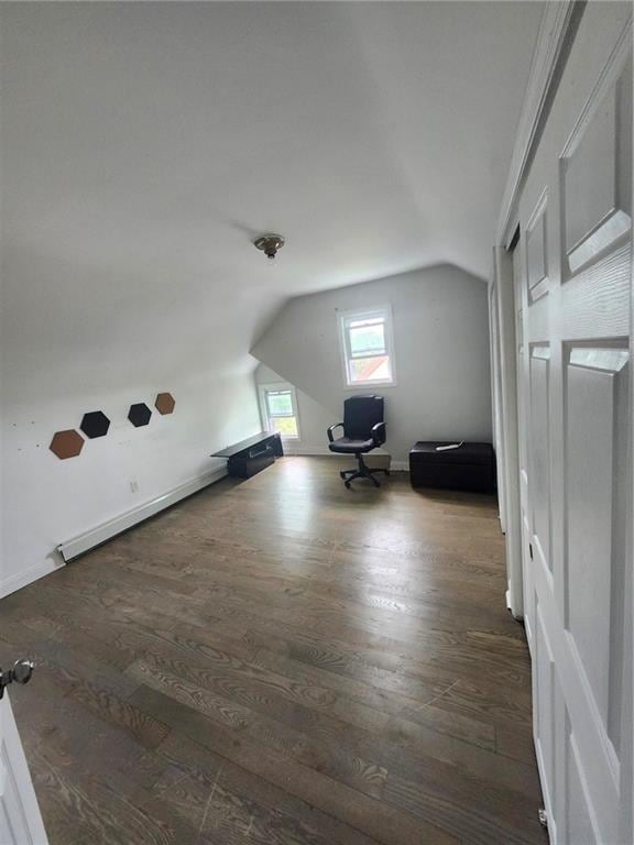 bonus room with lofted ceiling, baseboard heating, and dark hardwood / wood-style floors