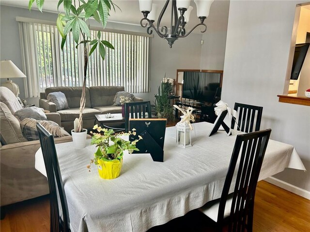 dining room with wood-type flooring and an inviting chandelier