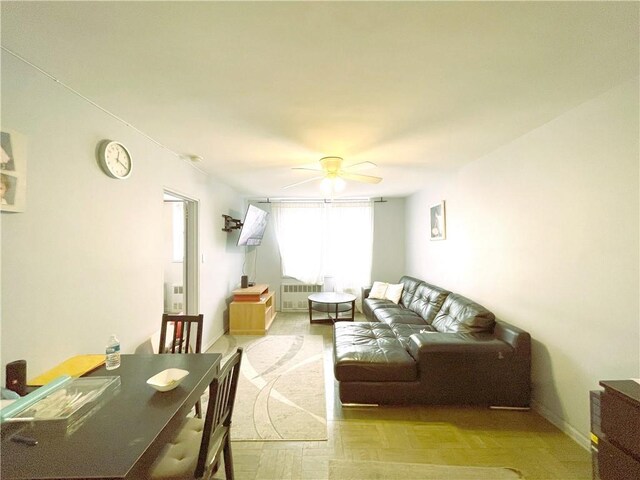 living room featuring ceiling fan, radiator, and light parquet floors