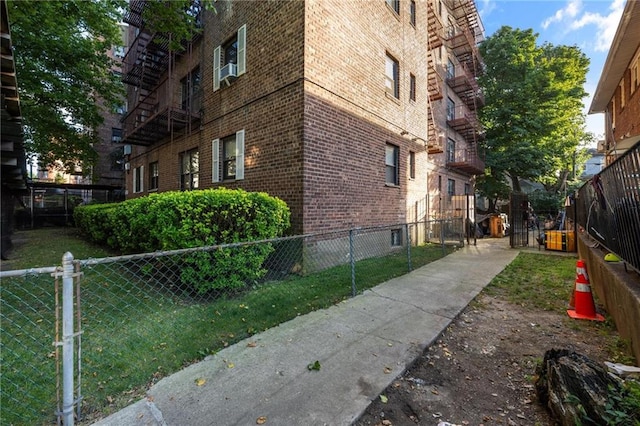 view of side of home with fence and brick siding