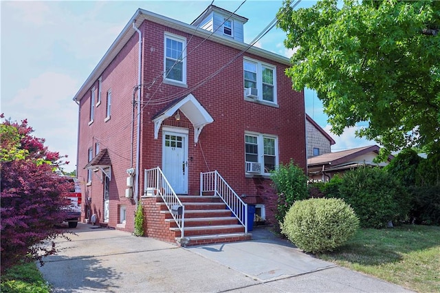 view of front of property with brick siding and cooling unit