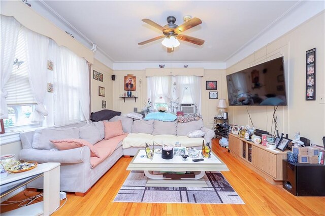 living room featuring light hardwood / wood-style floors, ornamental molding, and ceiling fan