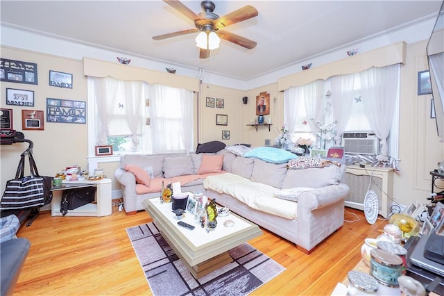 living room with radiator heating unit, cooling unit, ceiling fan, and wood finished floors