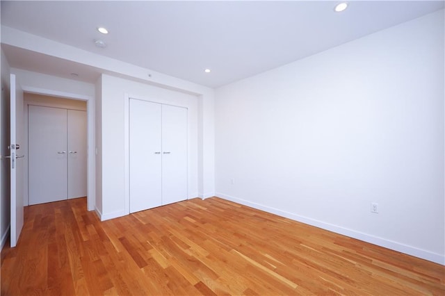 unfurnished bedroom featuring wood-type flooring and a closet