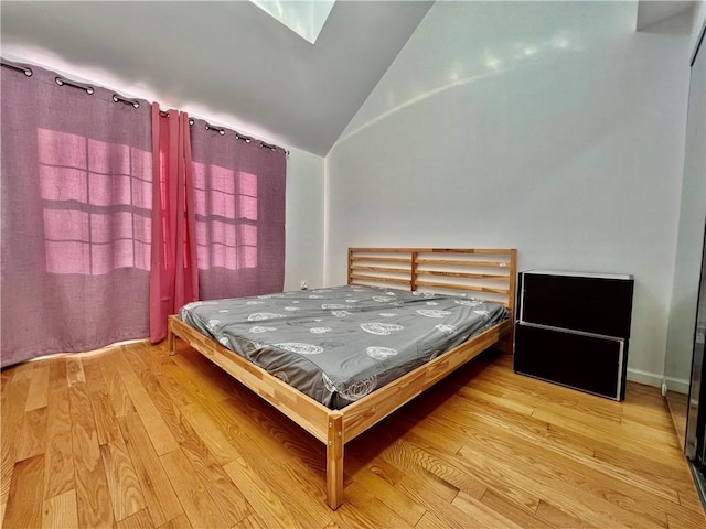 bedroom featuring wood-type flooring and vaulted ceiling