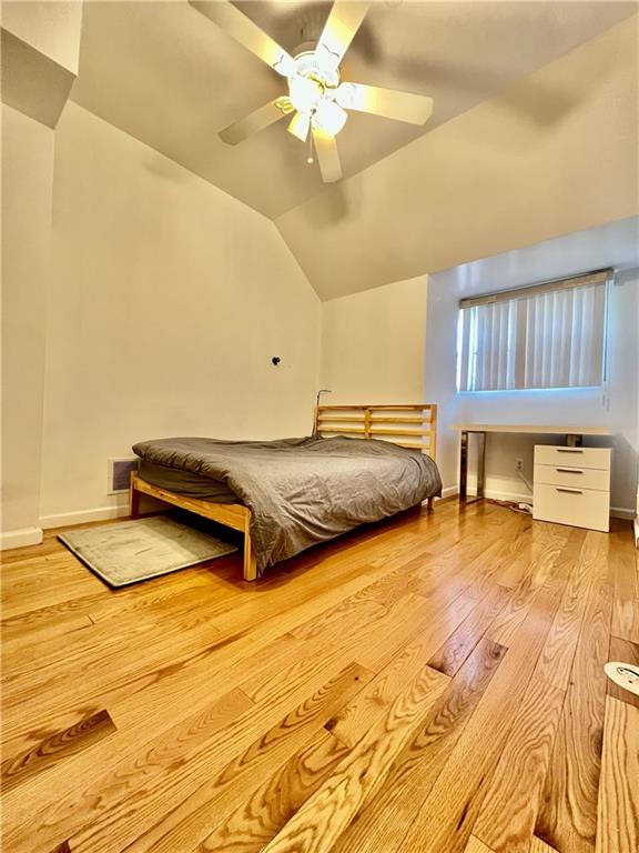 bedroom with lofted ceiling, light hardwood / wood-style flooring, and ceiling fan