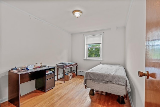 bedroom featuring baseboard heating and light hardwood / wood-style flooring