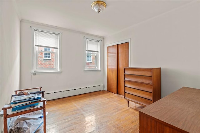 interior space with baseboard heating, a healthy amount of sunlight, and light wood-type flooring