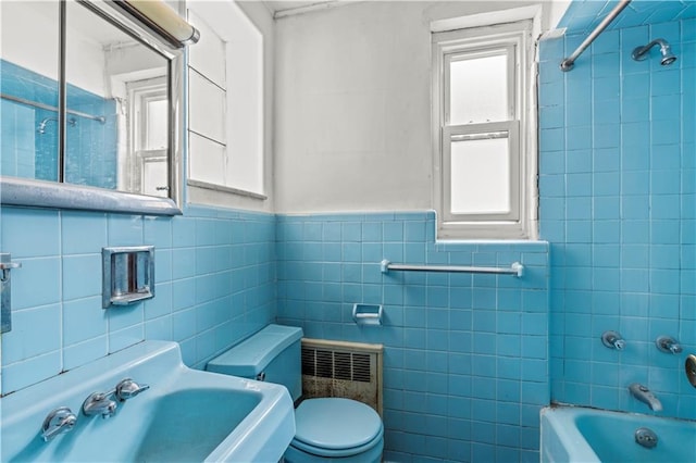 full bathroom with tile walls, sink, tub / shower combination, and toilet