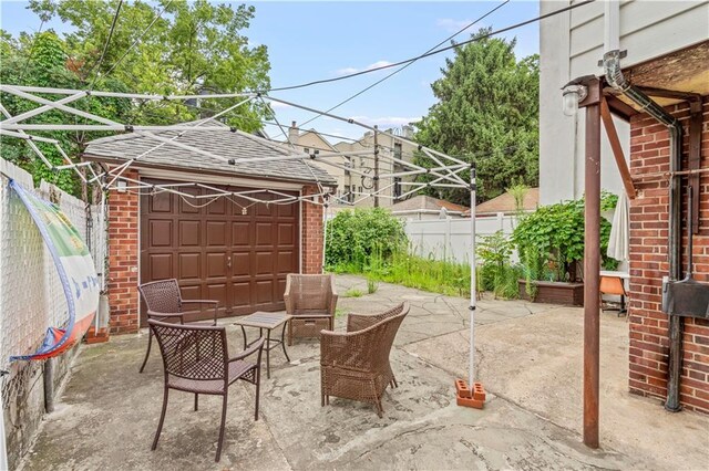 view of patio featuring outdoor lounge area, an outdoor structure, and a garage