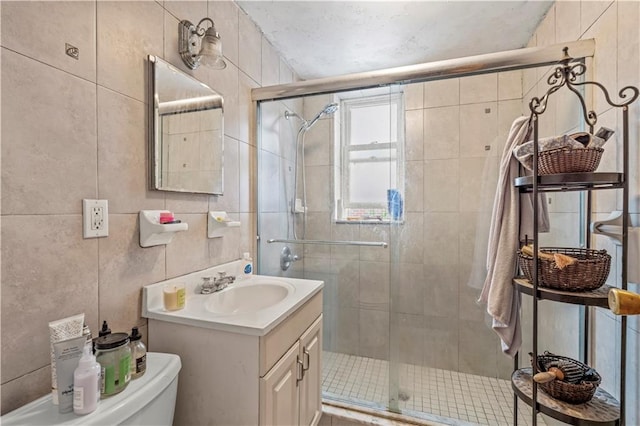 bathroom with vanity, toilet, walk in shower, and tile walls